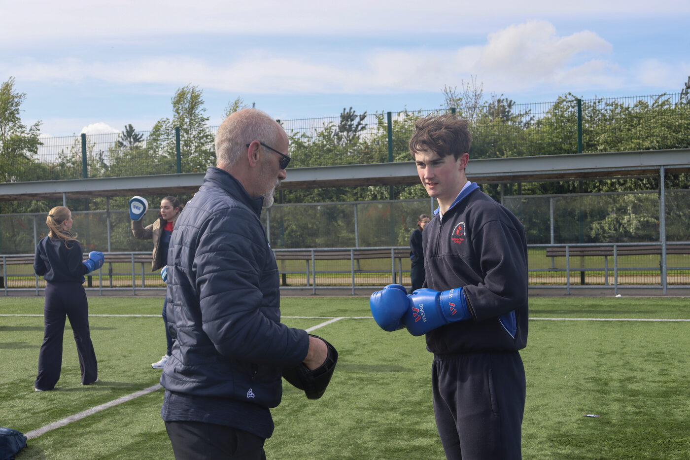 A coach guiding a student through a boxing drill at the TY Festival